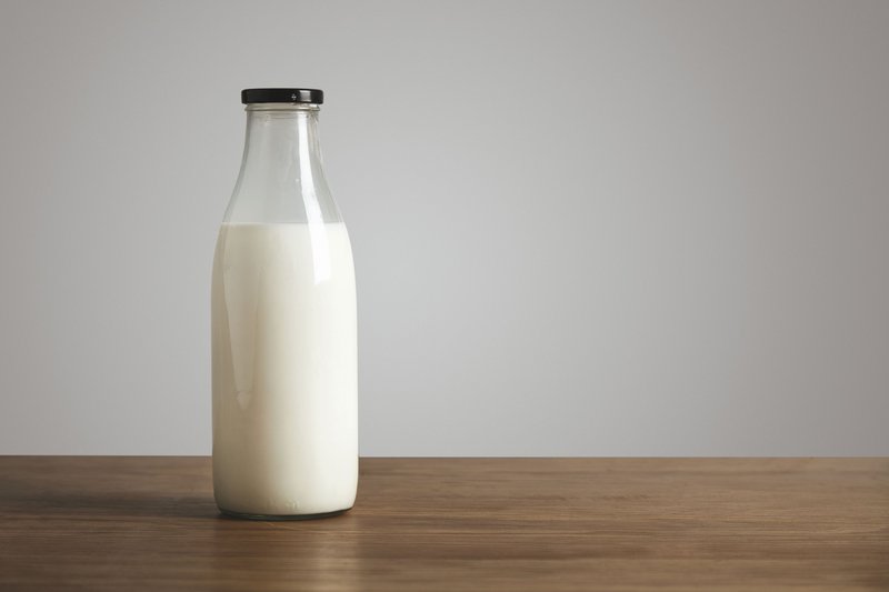 simple-vintage-bottle-filled-with-fresh-milk-thick-wooden-table-closed-with-black-cap-cafe-shop.jpg